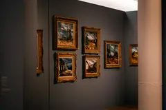 Elegant art gallery with framed paintings on a dimly lit wall