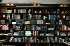 Richly decorated bookshelf filled with books, artifacts, and collectible decor