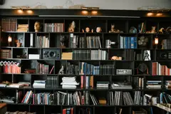 Richly decorated bookshelf filled with books, artifacts, and collectible decor