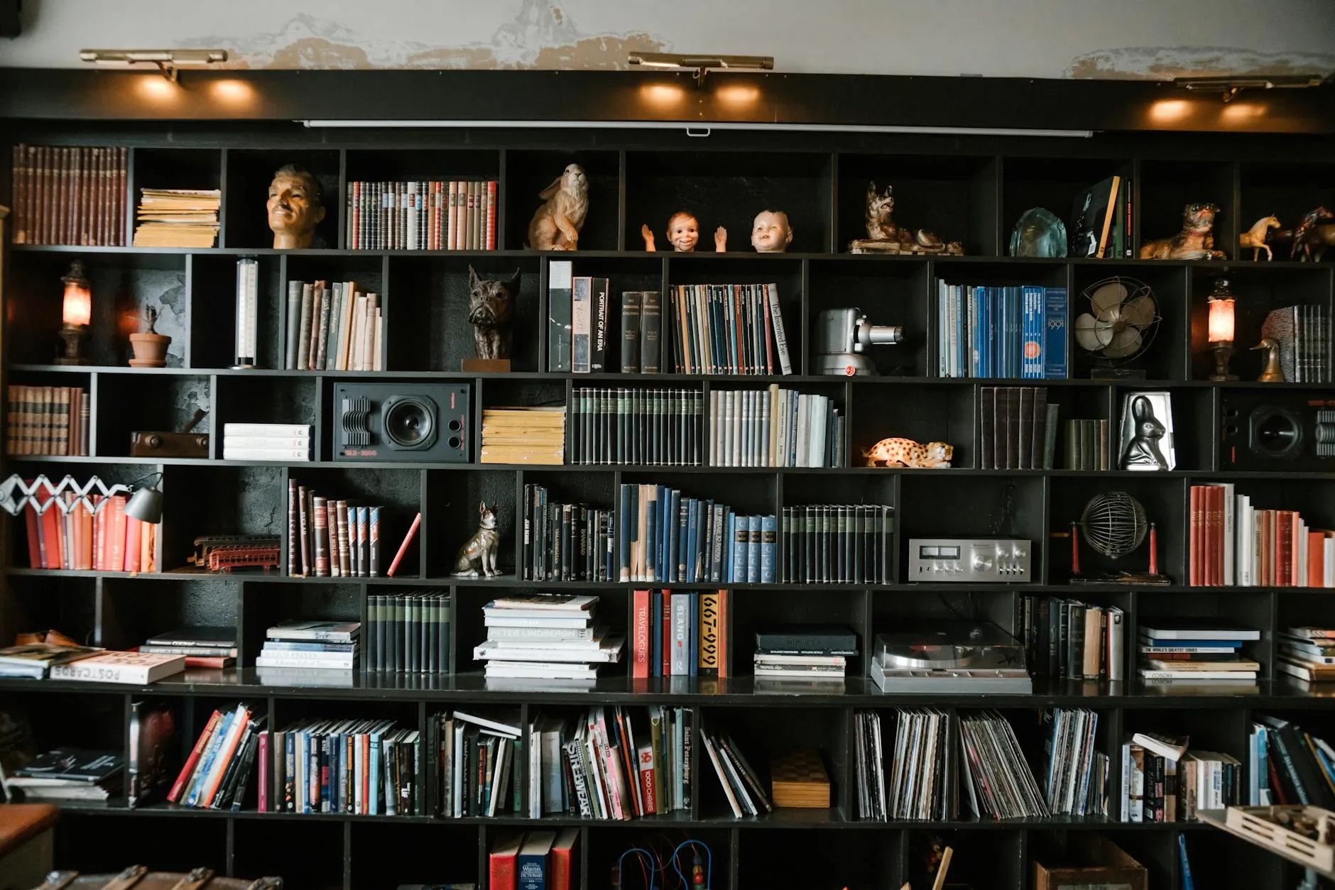 Richly decorated bookshelf filled with books, artifacts, and collectible decor