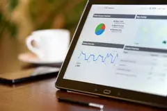 Tablet displaying analytics charts on a wooden office desk