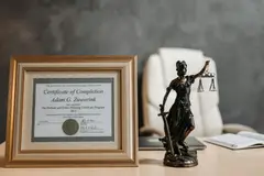 Legal certificate and Lady Justice figurine on a law office desk